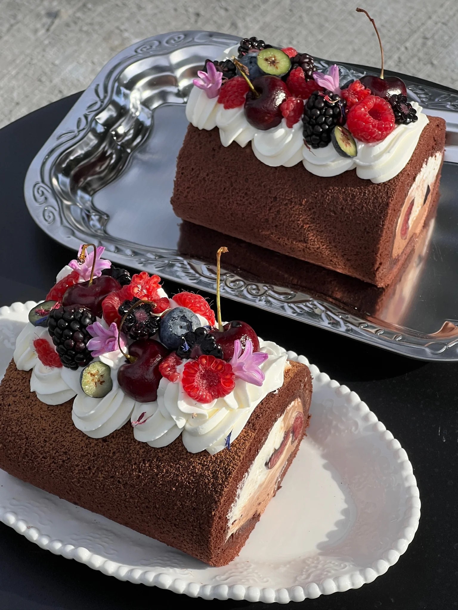 Chocolate cake rolls topped with cream and fresh berries