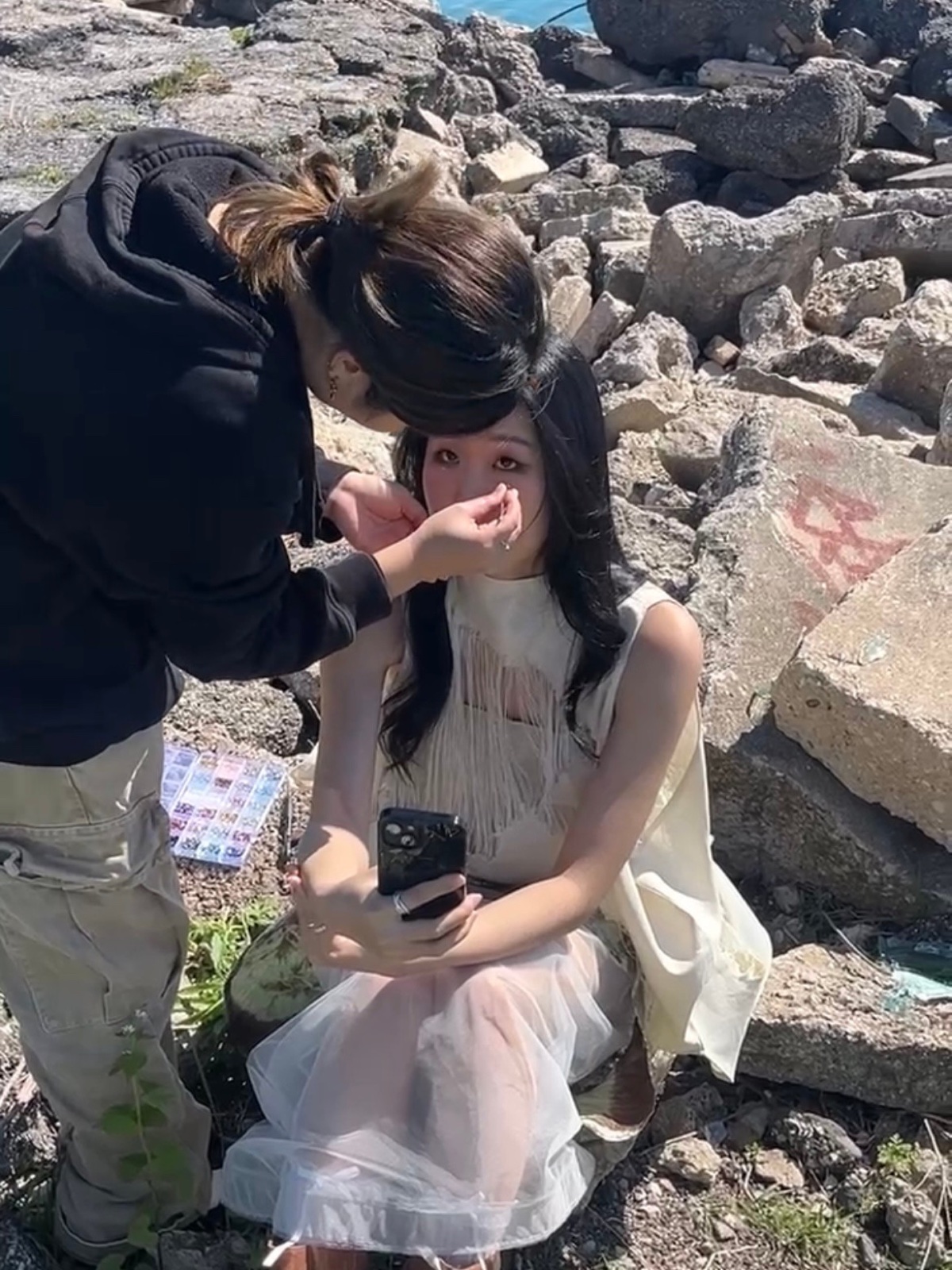 Vicky applying makeup to a model on the rocks