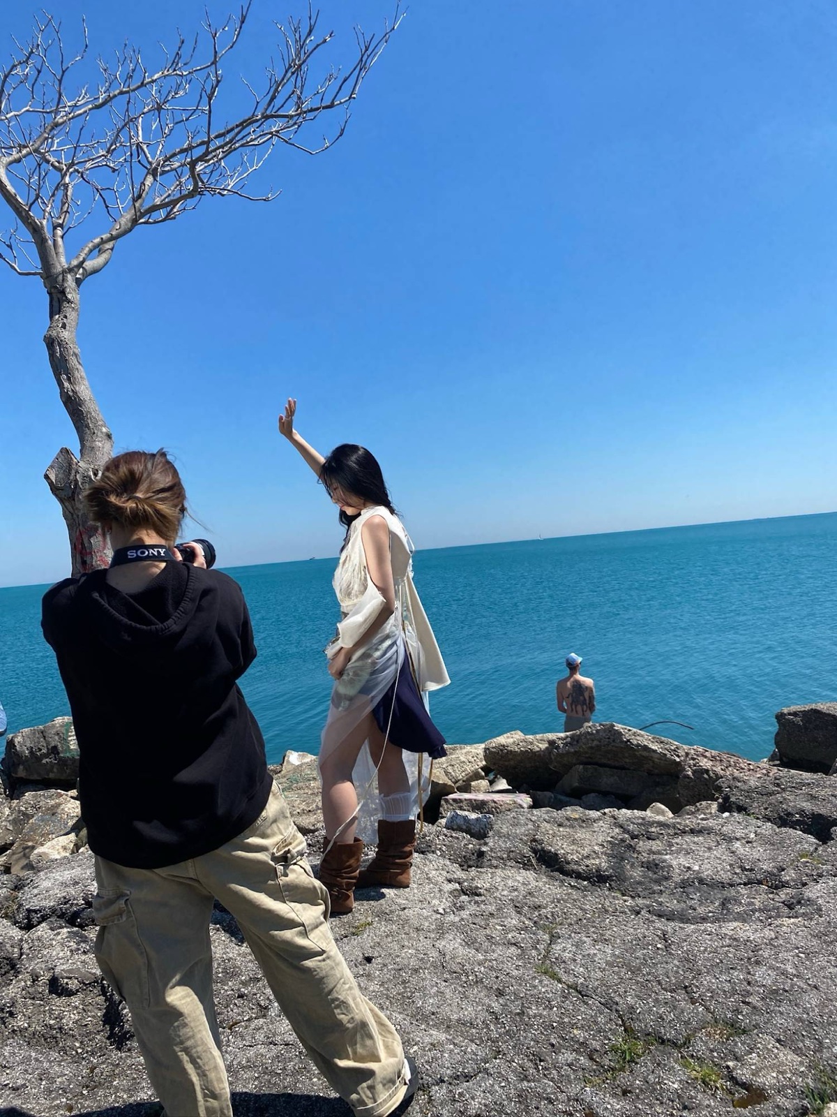 Vicky photographing a model on the rocks by the lake