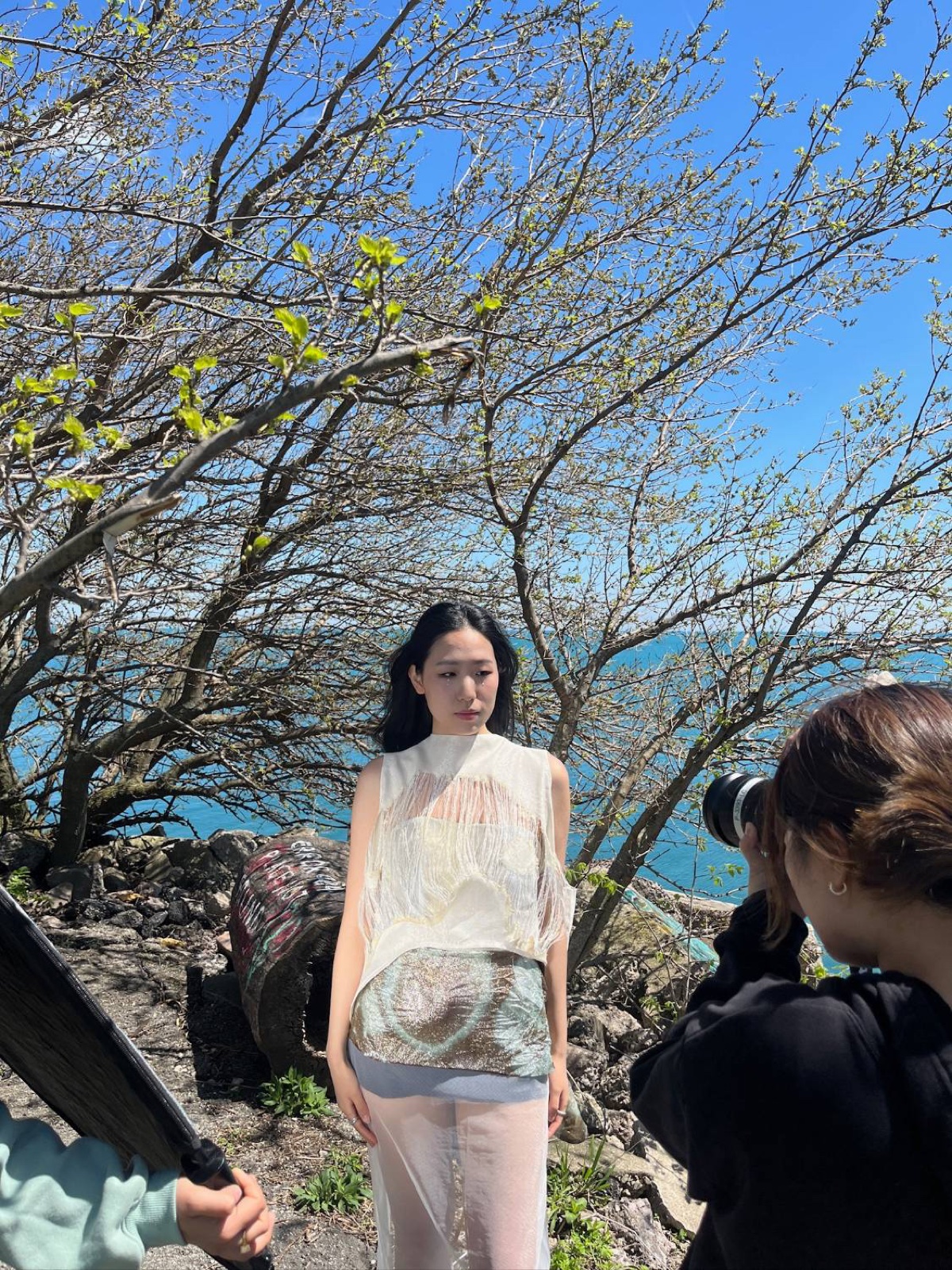 Vicky photographing a model under a tree by the lake